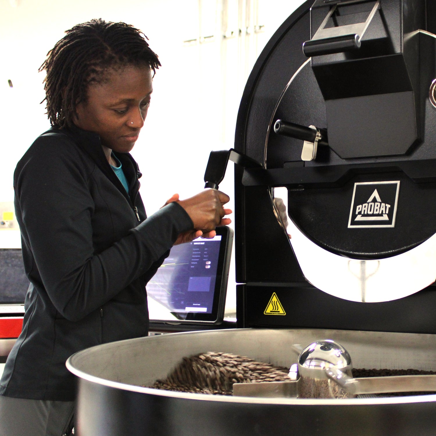 Founder inspecting freshly roasted beans at the Probat roaster in Georgetown, Texas.